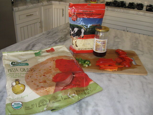 Ingredients I used for a low fodmap friendly pizza including mozzarella, olives, green onion tops, tomato and red pepper