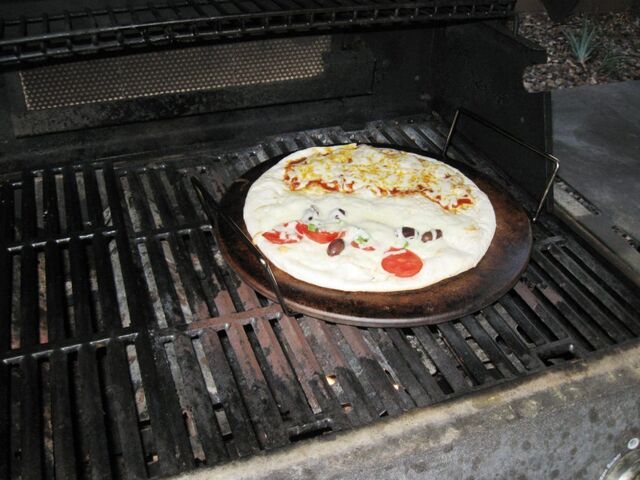 Pizza cooking on a stone in the grill - 10 minutes on a preheated stone and good to go