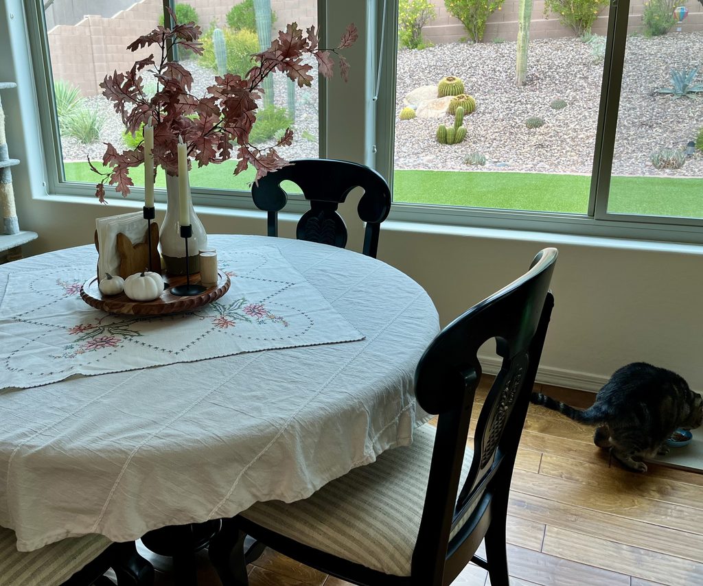 traditional fall decor in a breakfast nook with black chairs and maple leaves