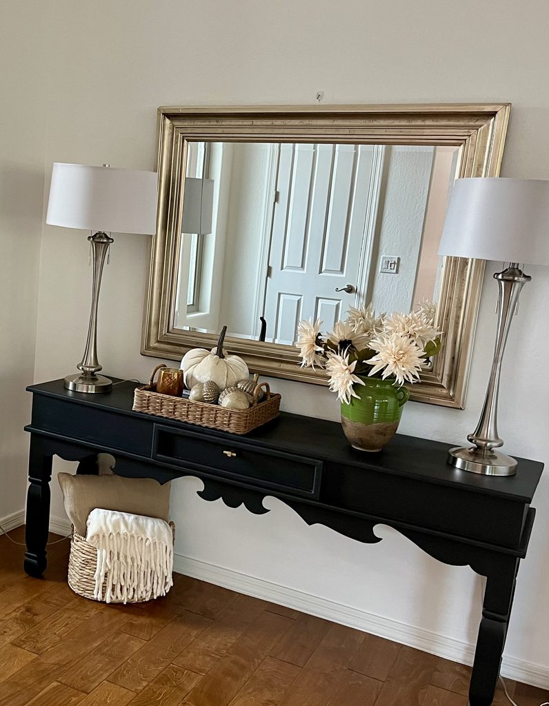 fall decor styled on an entryway console with pumpkins and flowers