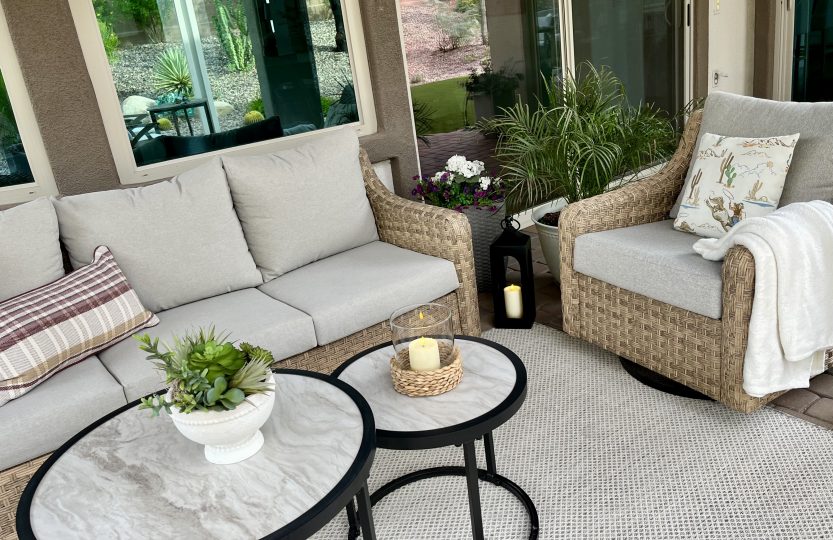Minimal fall patio with plaid pillows, cream throw blanket and cactus centerpiece